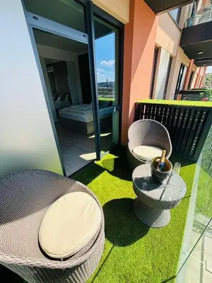 a balcony with two wicker chairs and a table at Belgrade Waterfront-Beograd na vodi Galaxy Apartment in Belgrade