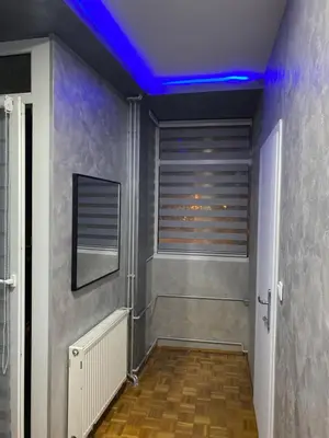a hallway with a blue light on the ceiling at Play Apartman Obrenovac in Obrenovac