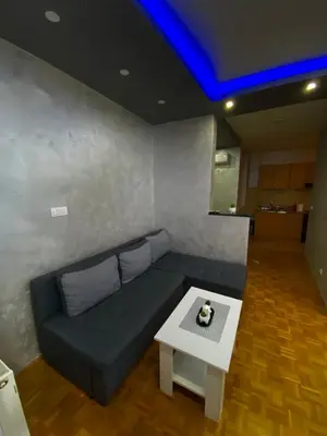 a living room with a couch and a table at Play Apartman Obrenovac in Obrenovac