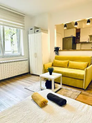 a living room with a yellow couch and a table at Golden Oasis in Belgrade
