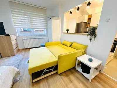 a living room with a yellow couch and a table at Golden Oasis in Belgrade