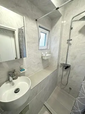a white bathroom with a sink and a shower at Golden Oasis in Belgrade
