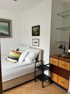 a bedroom with a bed with white pillows and a dresser at St. Mark in Belgrade