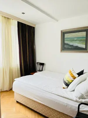 a bedroom with a large white bed in front of a window at St. Mark in Belgrade