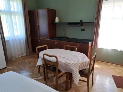 a room with a table and chairs and a bed at Eagles Court - Orlovski Vrt in Staji°evo