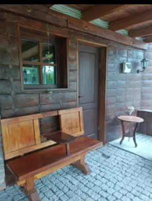 a room with a wooden bench and a table at Jablanicki Refugium in Pružatovac