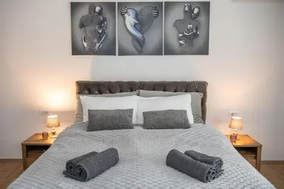 a bedroom with a bed with three pictures on the wall at Carska oaza in Lukino Selo