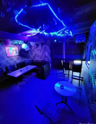 a room with blue lights and tables and chairs at Kuća za proslave i odmor ZMAJEVO GNEZDO in Pe°ani