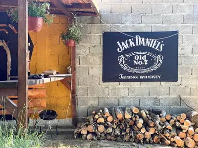 a sign on a wall with a pile of logs at Kuća za proslave i odmor ZMAJEVO GNEZDO in Pe°ani
