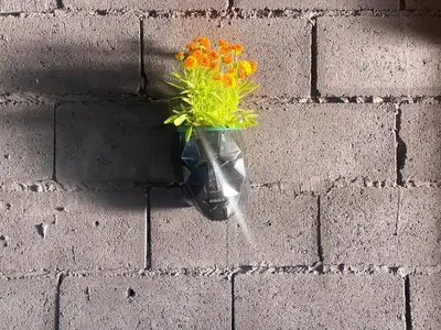 a vase filled with flowers on a brick wall at Kuća za proslave i odmor ZMAJEVO GNEZDO in Pe°ani