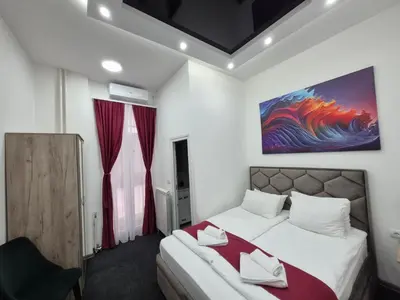a bedroom with a bed and a painting on the wall at Authentic Belgrade Centre - 4 Suites in One Space, with patios in courtyard for smokers in Belgrade