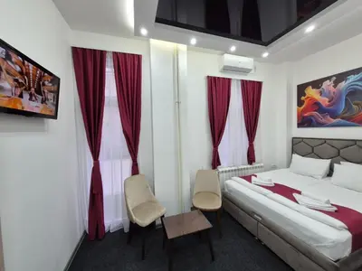 a bedroom with a bed and two chairs in it at Authentic Belgrade Centre - 4 Suites in One Space, with patios in courtyard for smokers in Belgrade