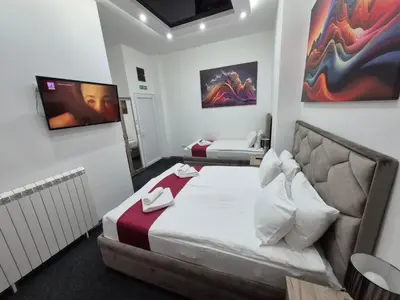 a small room with a bed and a tv at Authentic Belgrade Centre - 4 Suites in One Space, with patios in courtyard for smokers in Belgrade