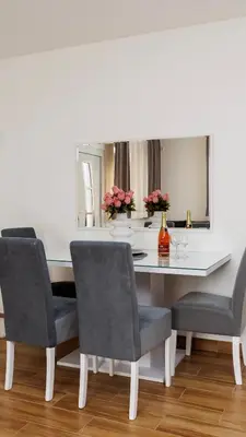 a dining room table with two chairs and a mirror at Shiny in Bele Vode
