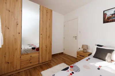 a bedroom with a bed and a wooden closet at Shiny in Bele Vode