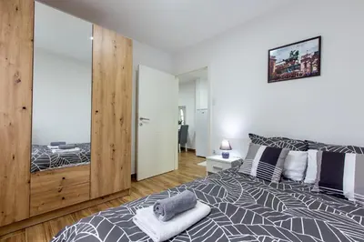 a bedroom with a bed and a large mirror at Apartman Aki in Bele Vode