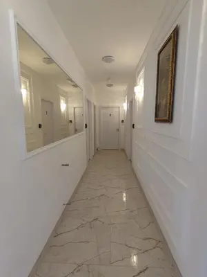 a hallway with white walls and a tile floor at AIRPORT APARTMANI HAPPY HOUSE free parking & early check-in in Surčin