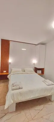 a bedroom with a large white bed in a room at AIRPORT APARTMANI HAPPY HOUSE free parking & early check-in in Surčin