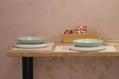 two bowls sitting on a wooden table with plates at AIRPORT APARTMANI HAPPY HOUSE free parking & early check-in in Surčin