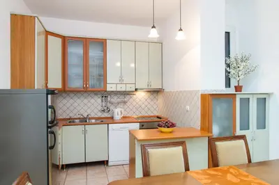 a kitchen with white cabinets and a wooden table at Central Belgrade Apartment 2 in Belgrade