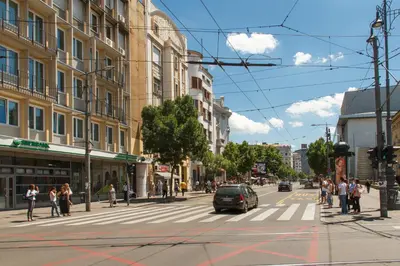 a busy city street with a car on a crosswalk at Central Belgrade Apartment 2 in Belgrade