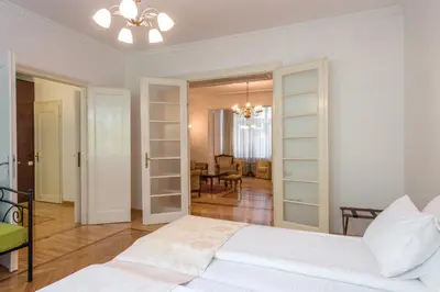 a bedroom with a white bed and a living room at Central Belgrade Apartment 2 in Belgrade