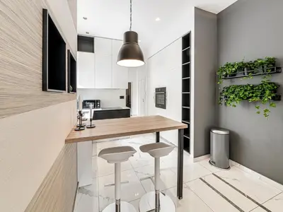 a kitchen with a wooden counter and stools at Enjoy B-52 Crown in Belgrade
