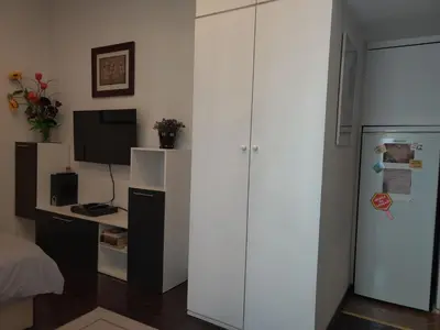 a kitchen with white cabinets and a refrigerator at Slavija Square Apartment Cvetni Trg in Belgrade