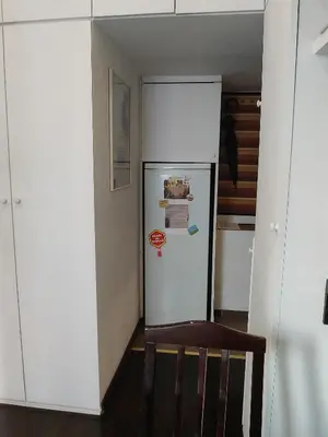 a white refrigerator in a kitchen with a wooden chair at Slavija Square Apartment Cvetni Trg in Belgrade