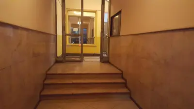 a hallway with stairs leading to a yellow door at Slavija Square Apartment Cvetni Trg in Belgrade