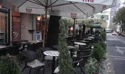 a row of tables and chairs outside of a restaurant at Slavija Square Apartment Cvetni Trg in Belgrade