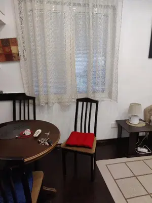 a dining room with a table and chairs and a window at Slavija Square Apartment Cvetni Trg in Belgrade