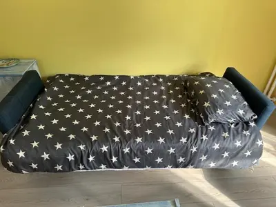a bed with a blanket with stars on it at Modern one bedroom in the center of Belgrade in Belgrade