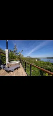 a bench on a deck with a view of the water at Honey Spa house in Novi Slankamen