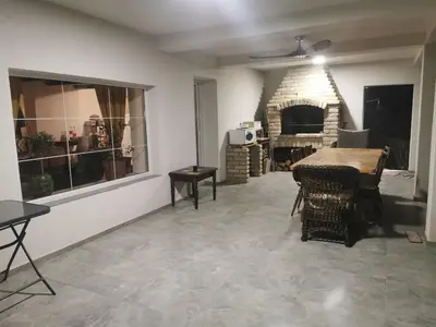 a living room with a table and a stone fireplace at Honey Spa house in Novi Slankamen