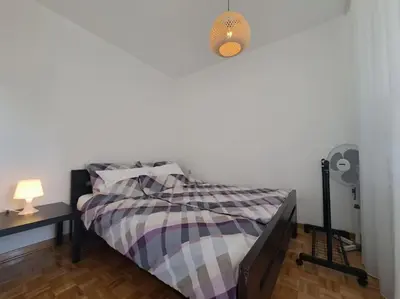 a bedroom with a bed and a table with a lamp at Cozy lux bedroom apt with balcony in Dorcol in Belgrade