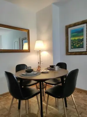 a table with chairs and a lamp in a room at Cozy lux bedroom apt with balcony in Dorcol in Belgrade