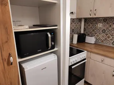 a small kitchen with a microwave and a stove at Cozy lux bedroom apt with balcony in Dorcol in Belgrade