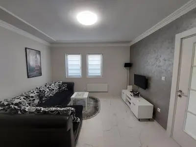 a living room with a couch and a tv at D&N Apartman in Ledine