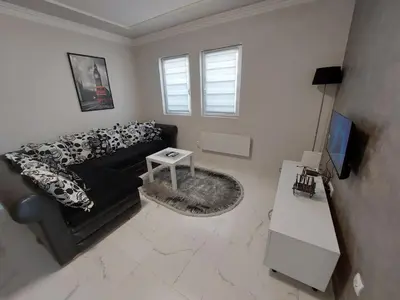 a living room with a black couch and a table at D&N Apartman in Ledine