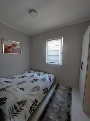 a small bedroom with a bed and a window at D&N Apartman in Ledine
