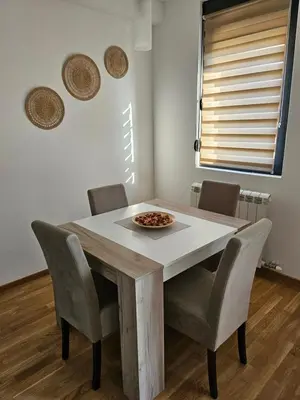 a dining room table with chairs and a bowl of food on it at Aurora lux in Belgrade