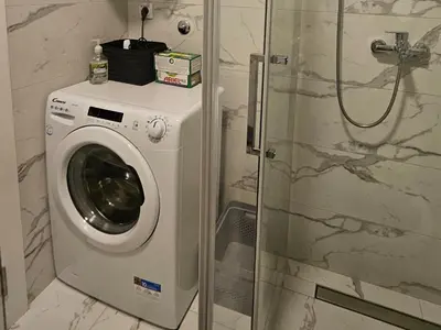 a washing machine in a bathroom with a shower at Aurora lux in Belgrade