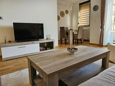 a living room with a television and a wooden coffee table at Aurora lux in Belgrade