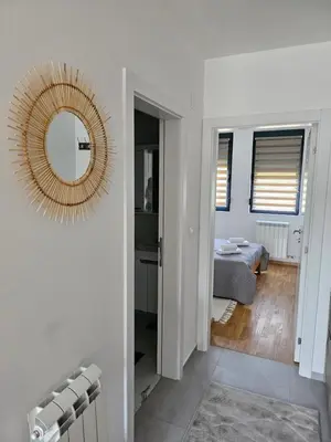 a white room with a mirror and a bedroom at Aurora lux in Belgrade