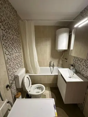 a bathroom with a toilet and a sink and a tub at Apartment 601 in Surčin