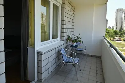 a balcony with a table and chairs and a window at Apartment 601 in Surčin