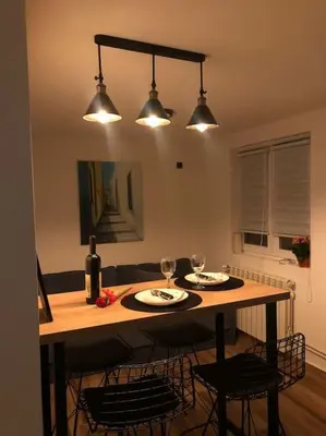 a kitchen with a table with two plates and wine glasses at Blue apartman in Belgrade
