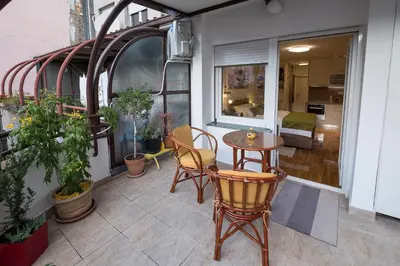 a balcony with a table and chairs on a building at Cozy studio with a terrace near Slavija square in Sajmište