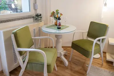 a small table with two chairs and a table with a bottle of wine at Cozy studio with a terrace near Slavija square in Sajmište